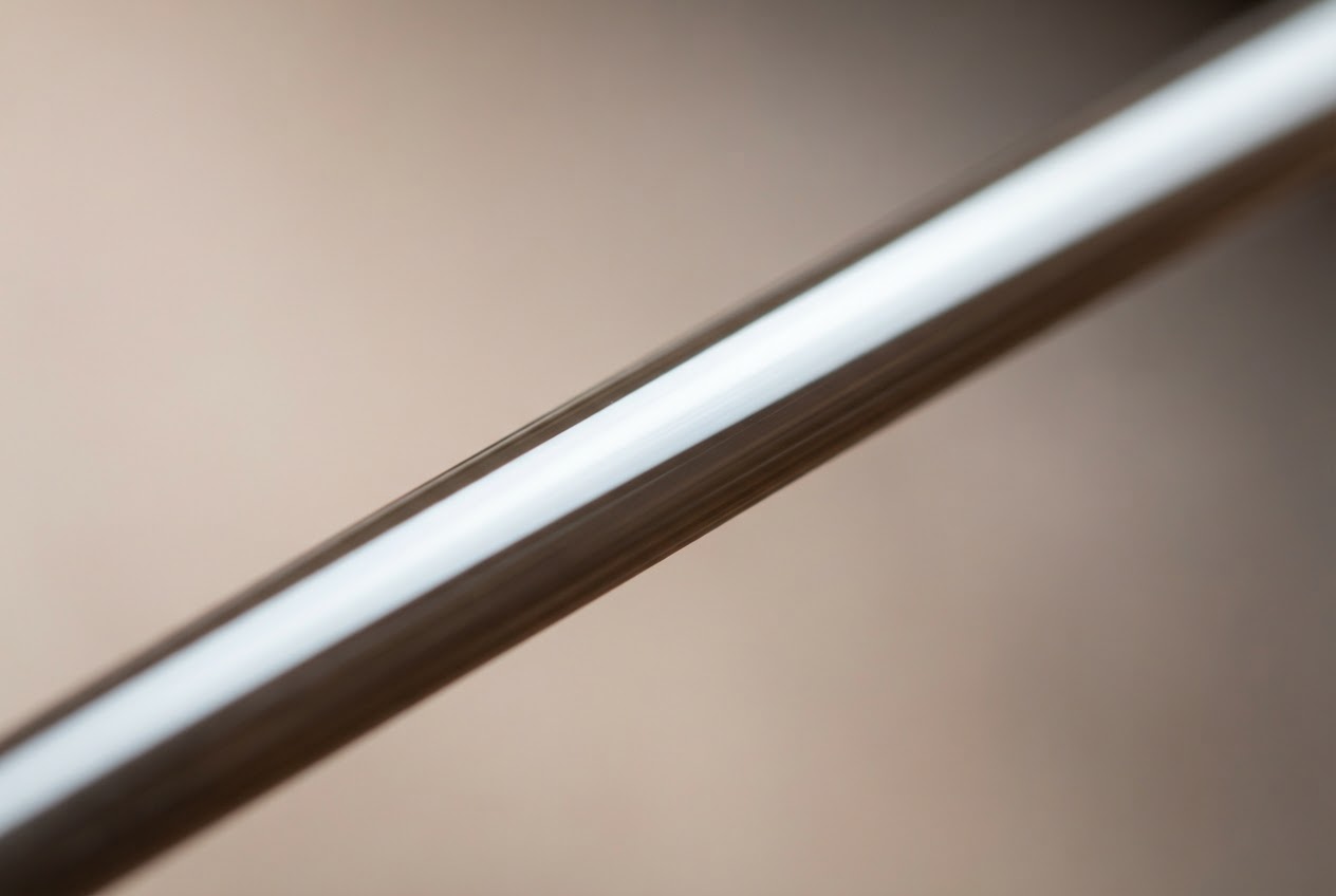Macro close-up of a single hair strand showing the smooth cuticle layer reflecting light.