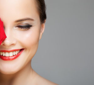 Make Up: Lächelnde Frau mit Lippenstift und Eyeliner