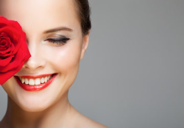 Make Up: Lächelnde Frau mit Lippenstift und Eyeliner