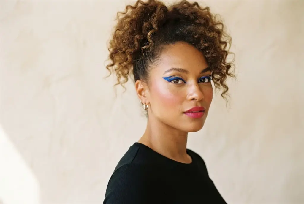 80er-inspirierter Look mit grafischem blauem Lidschatten und pinken Lippen.