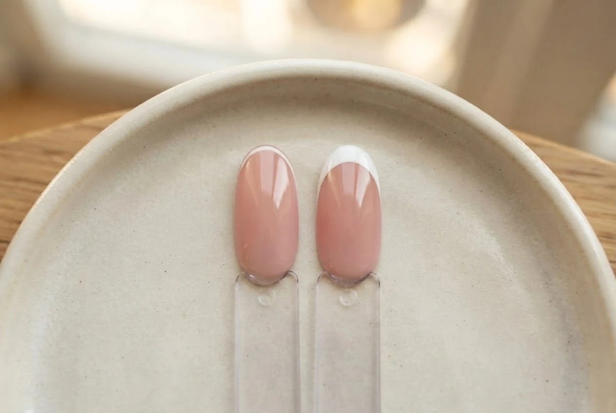 Zwei roséfarbene Musternägel zeigen eine sehr schmale und eine breitere weiße French-Spitze.