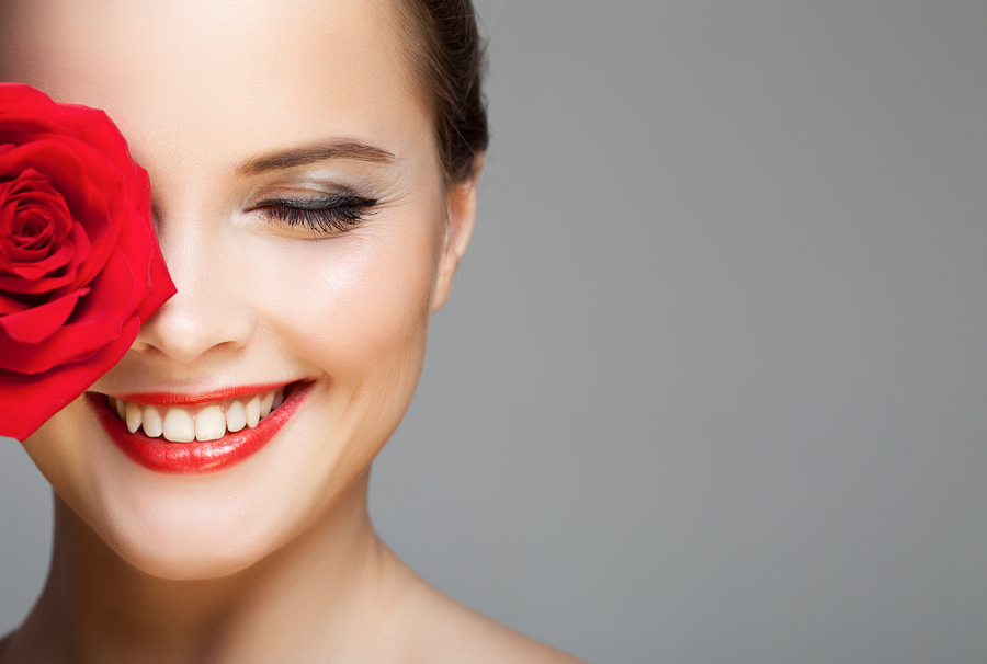Make Up: Lächelnde Frau mit Lippenstift und Eyeliner