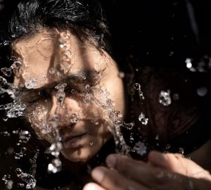 woman in black shirt with water droplets