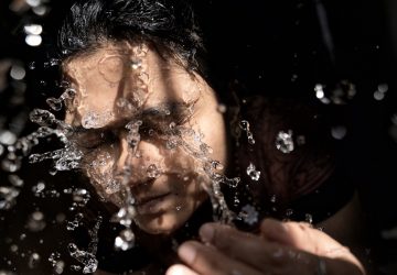 woman in black shirt with water droplets